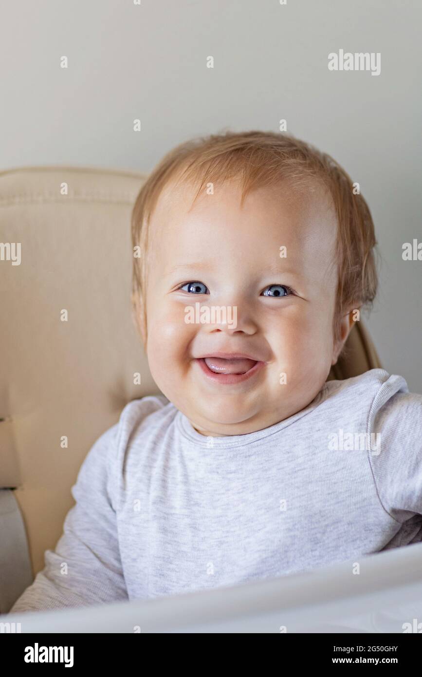 Cute caucasian infant girl ten months old sitting in baby chair and