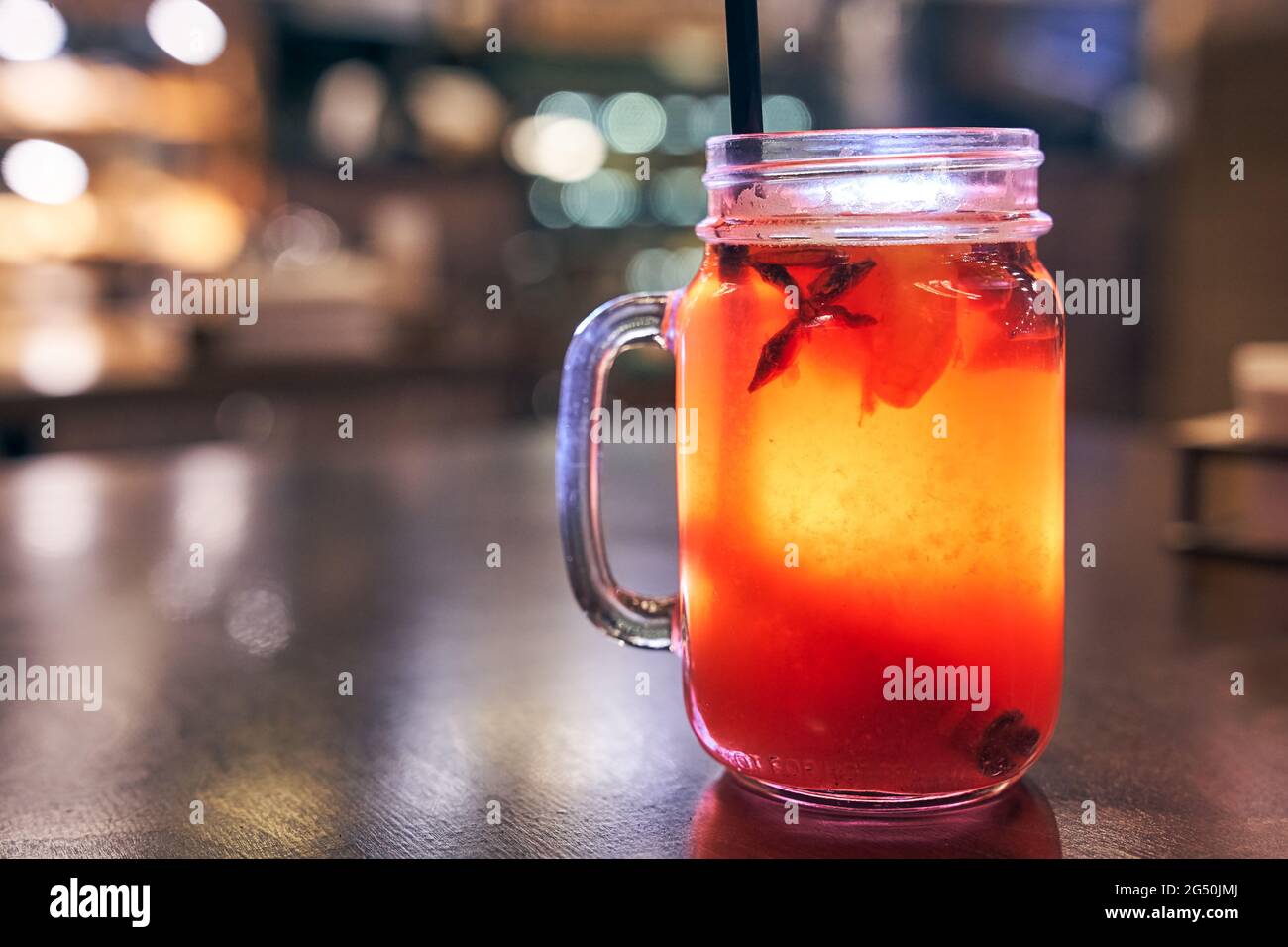 Christmas drink red non-alcoholic mulled wine with a straw on the background of the cafe interior, order for one Stock Photo
