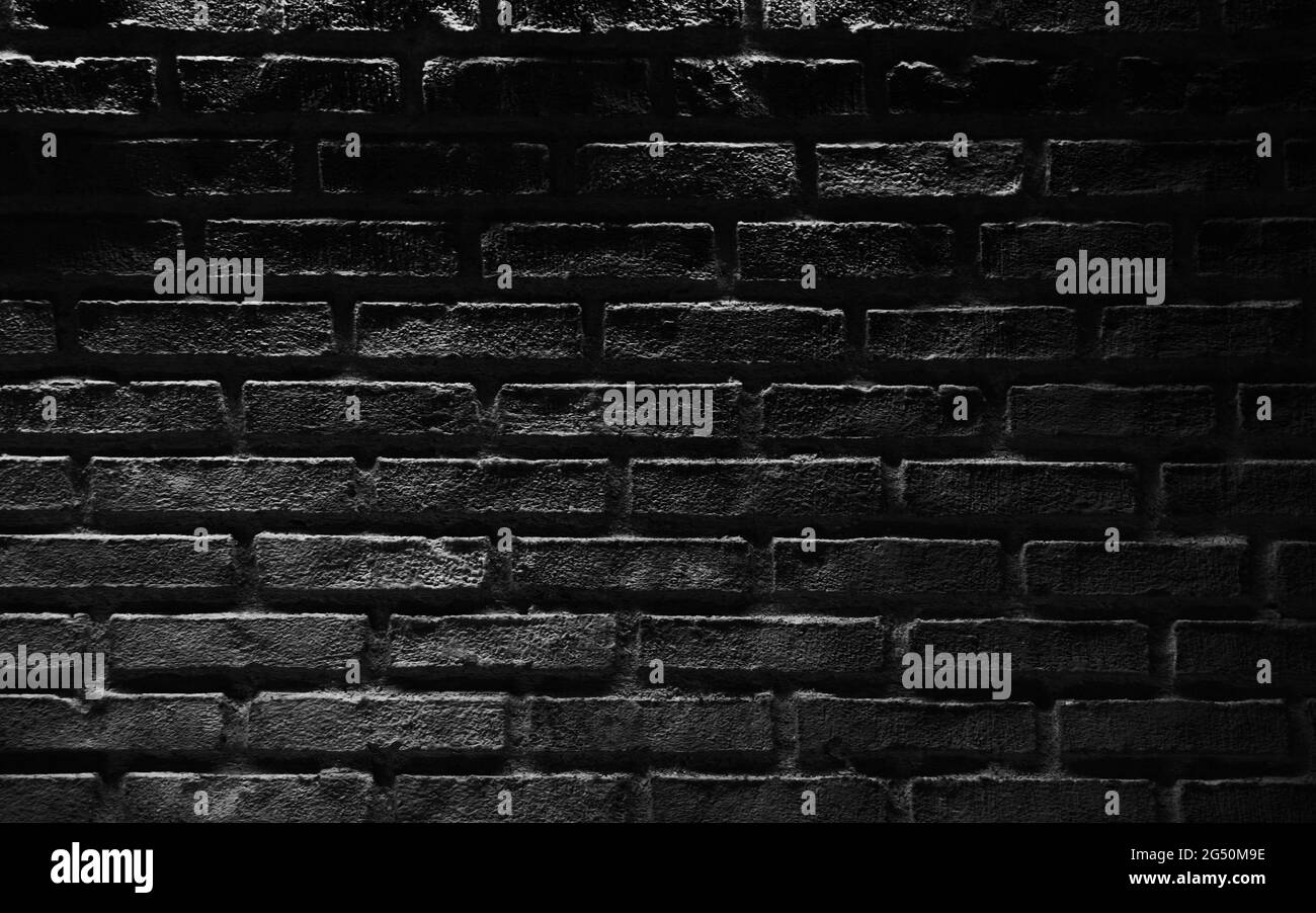 Black brick wall with top illumination effect. Background photo texture Stock Photo