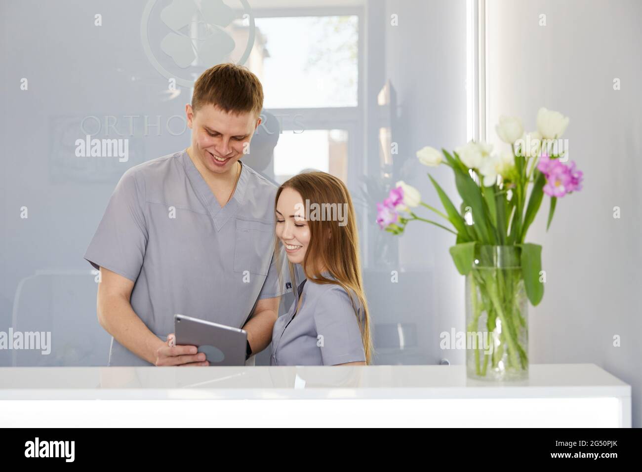 Dentist with dental nurse in modern dental office using tablet pc
