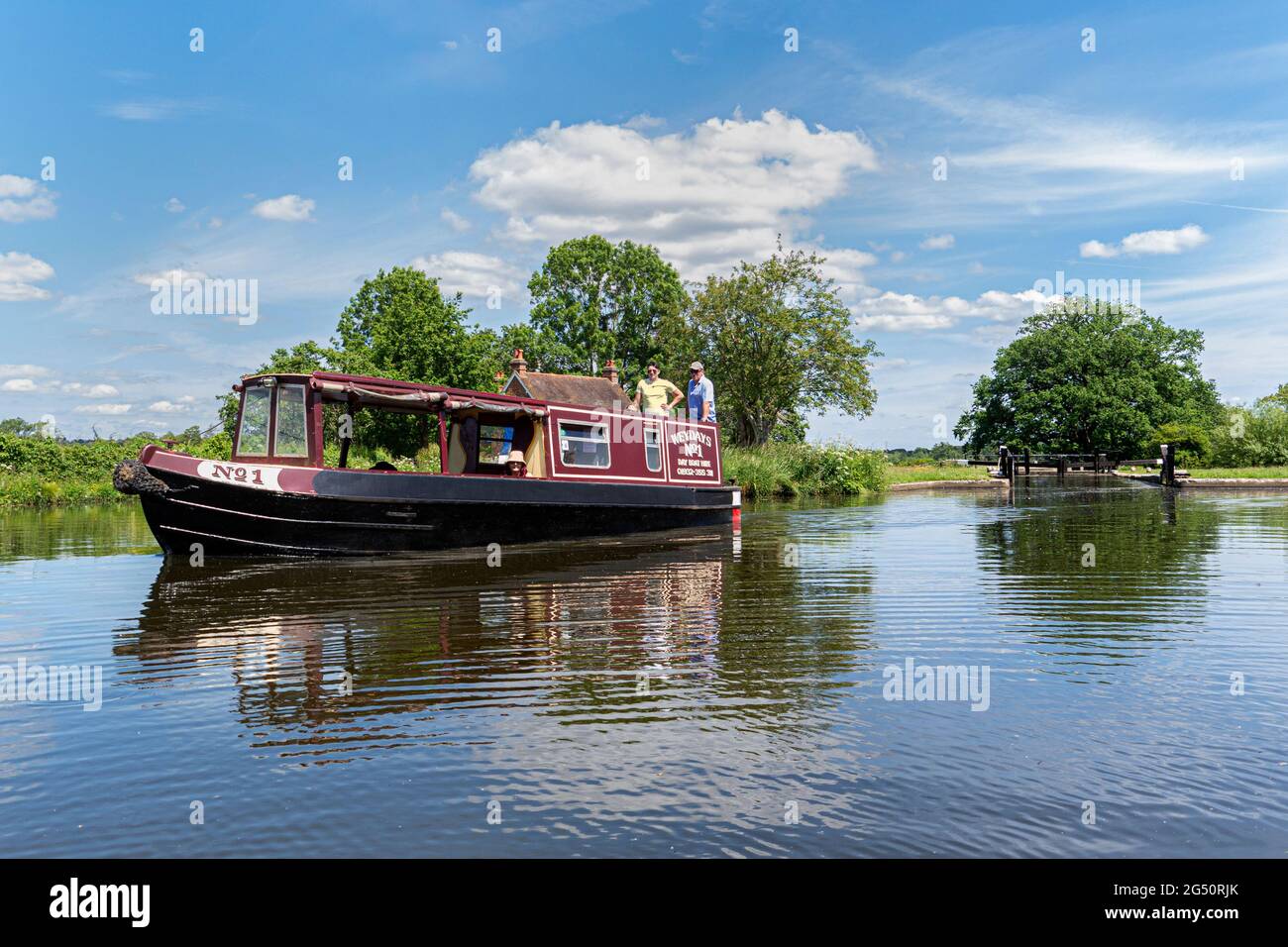 River Wey Navigations Traditional Staycation holiday hire narrowboat leaving Papercourt Lock on a still spring summer day River Wey Surrey England UK Stock Photo