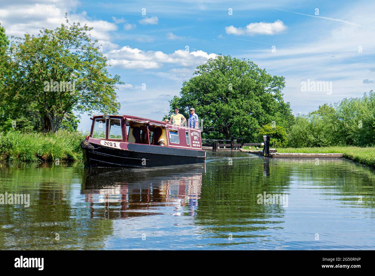 Staycation River Wey Navigations Traditional holiday hire narrowboat leaving Papercourt Lock on a still spring summer day River Wey Surrey England UK Stock Photo