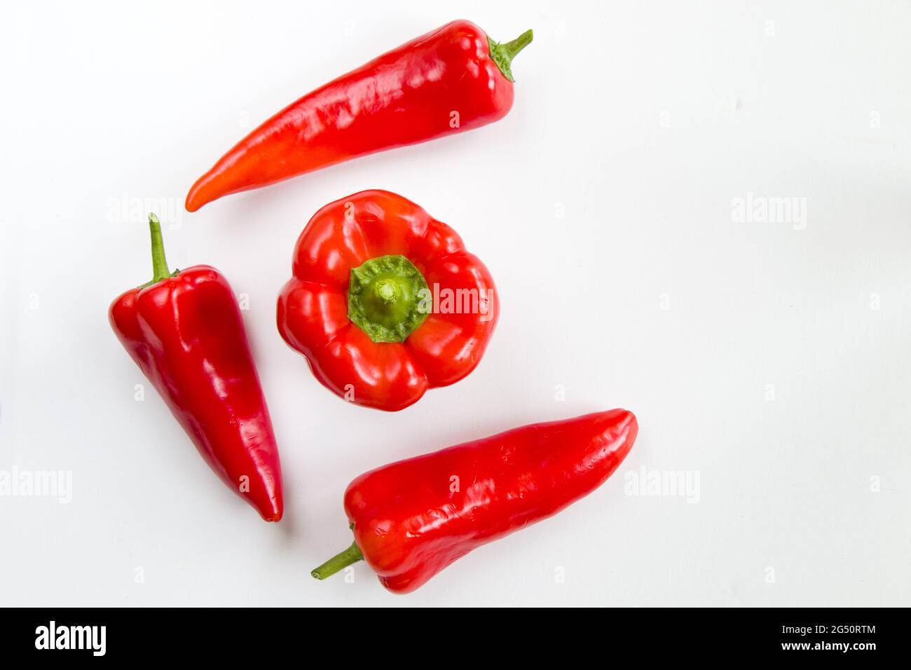 Top view of red bell peppers on a white background Stock Photo - Alamy