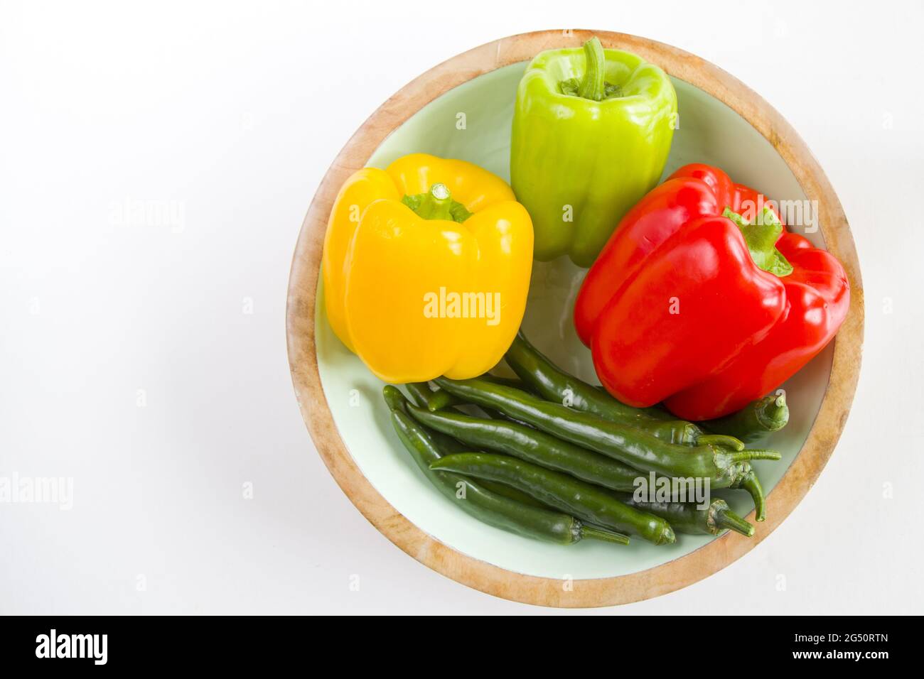 Top view of ripe bell and chili peppers in the bowl isolated on white ...