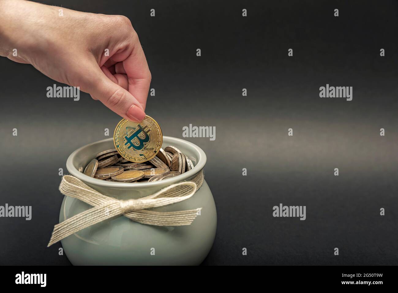 Investments, accumulation in cryptocurrency. Bitcoin in hand, female hand  puts a gold bitcoin coin into a pot of coins. digital money, place for text  Stock Photo - Alamy