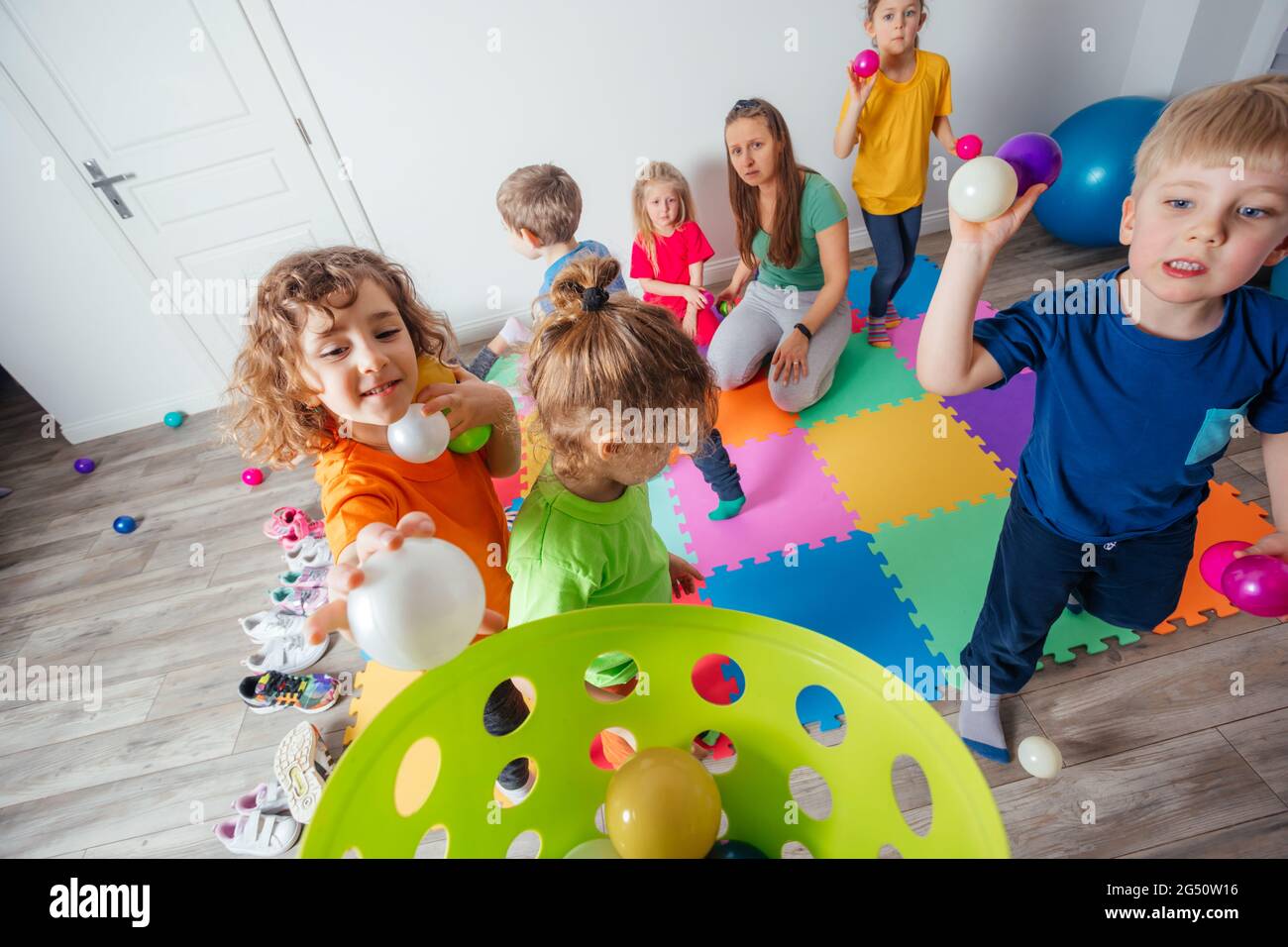 Sporty kids enjoying activities with young teacher Stock Photo - Alamy