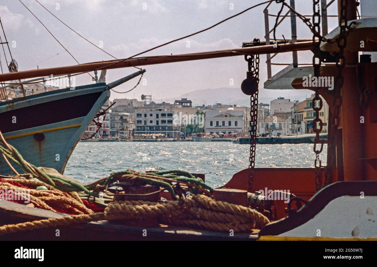 Archival image. The harbour at Agios Nikolaos in northern Crete with boats to the fore 1979. The town became famous when the BBC filmed The Lotus Eate Stock Photo