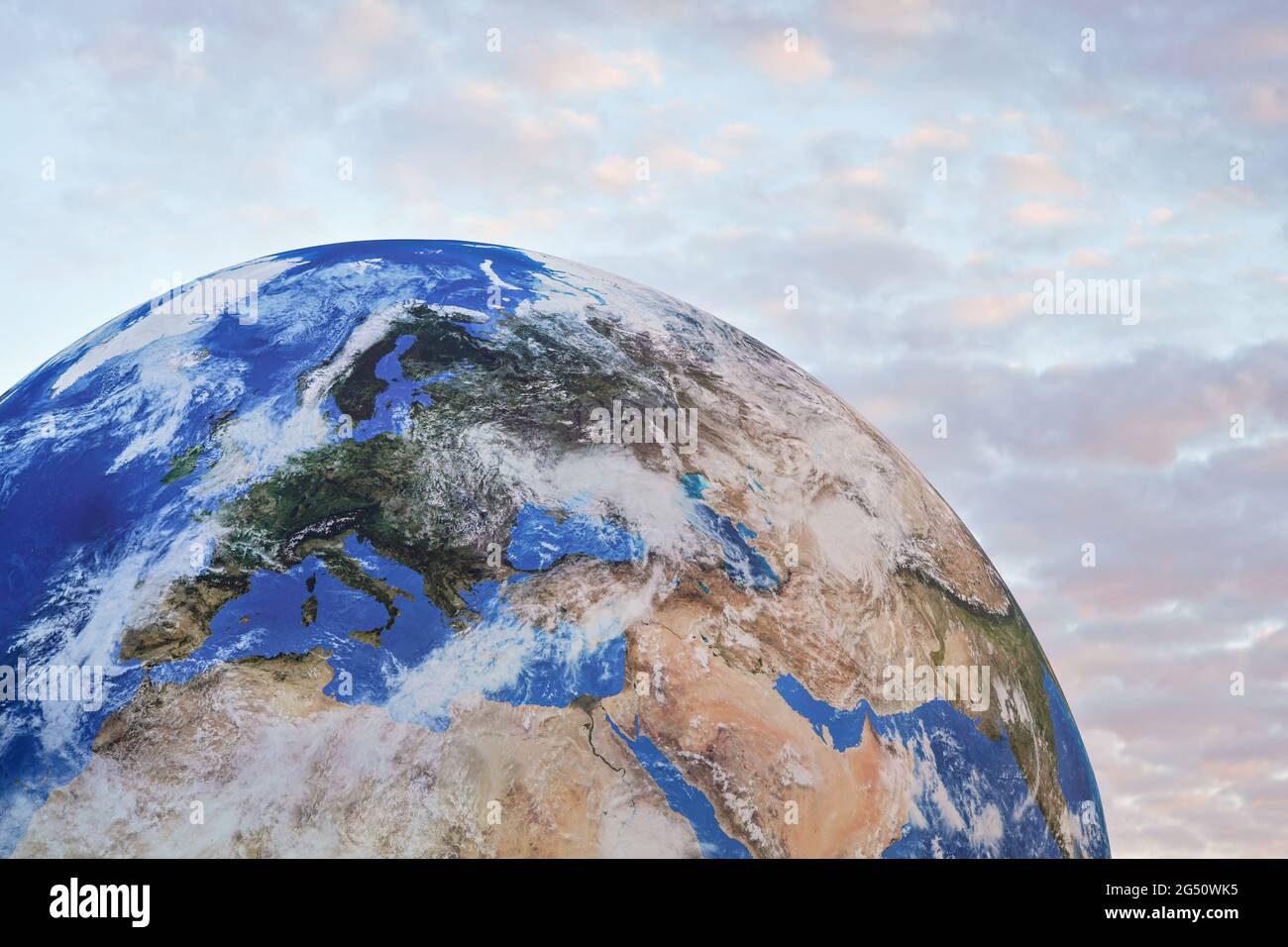 Large inflatable model of planet Earth, detail on Europe, small pink sunset clouds in background Stock Photo