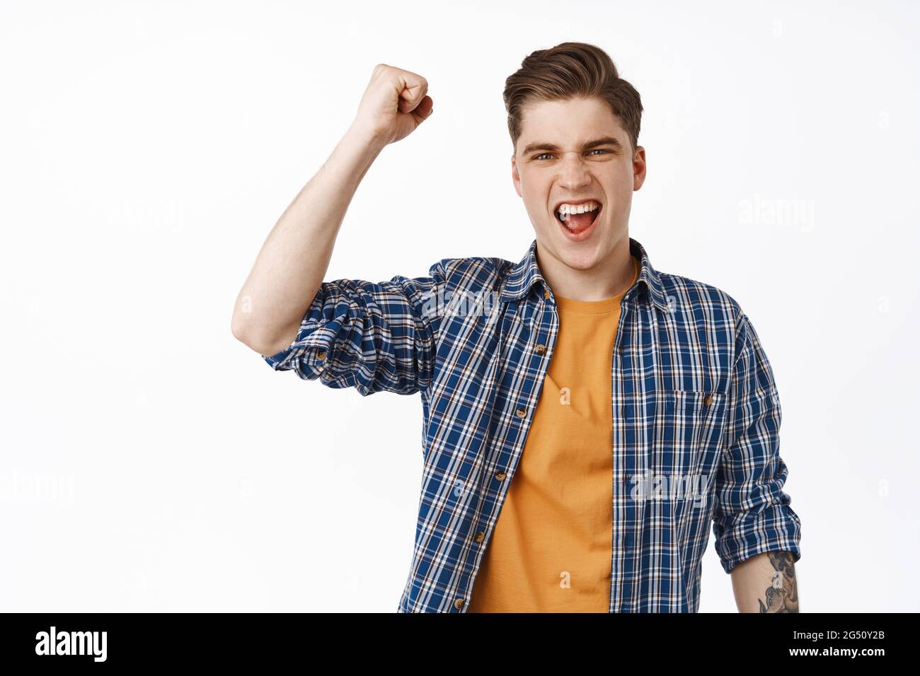 Fierce and excited young man chanting, fist pump and yelling, watching ...