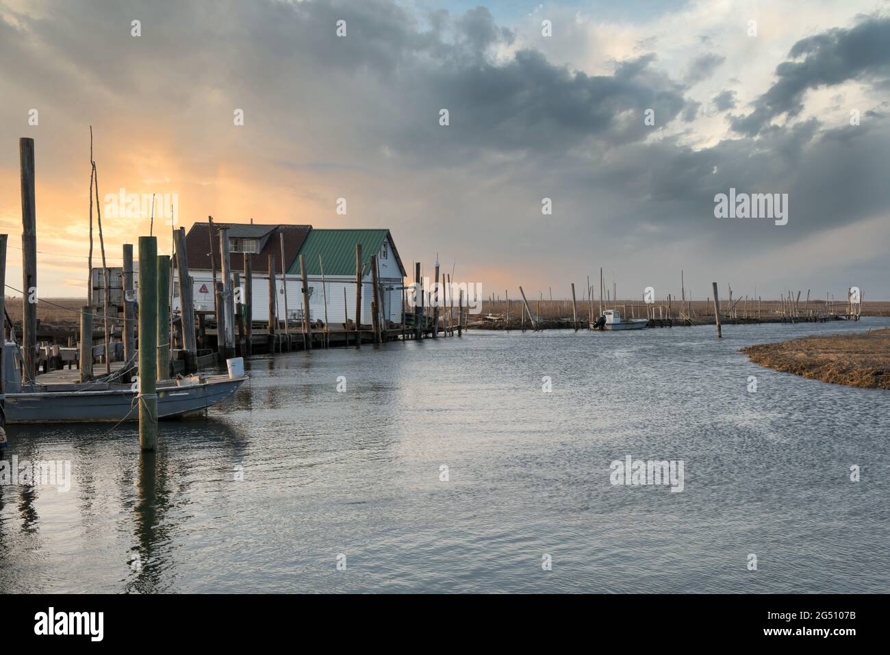 Fishing area with bait house and eatery, with a dramatic sky, dock, water and land. Stock Photo