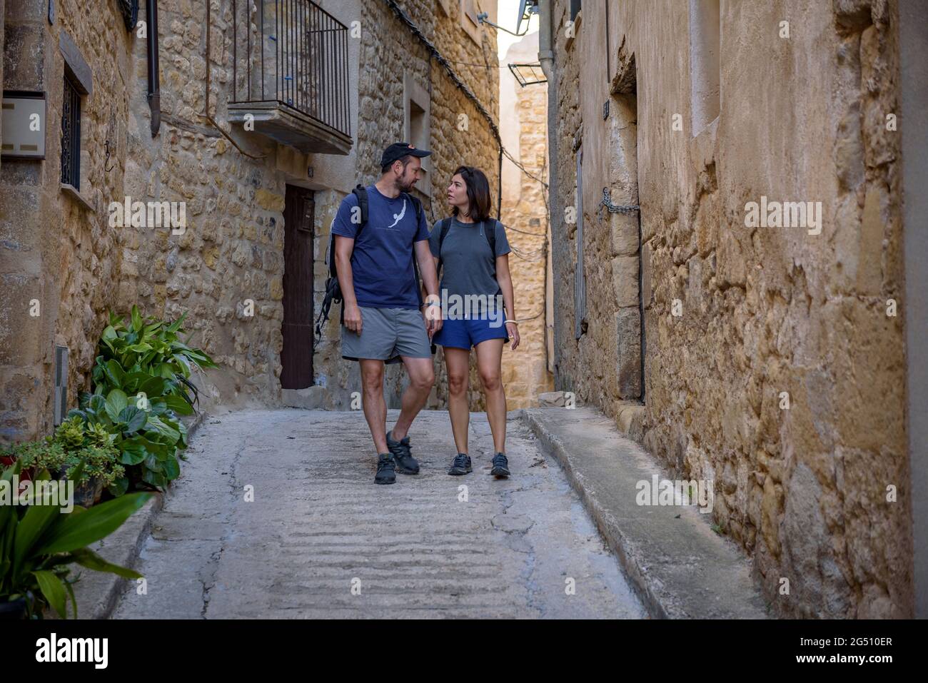 Couple walking through the historic center of Horta de Sant Joan (Tarragona, Catalonia, Spain) ESP: Pareja paseando por Horta de Sant Joan (Cataluña) Stock Photo