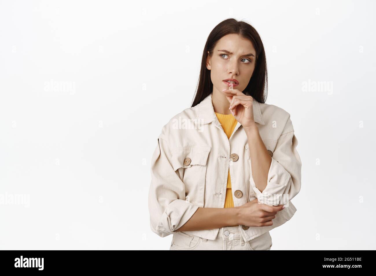 Hmm let me think. Thoughtful brunette woman furrows while ponder smth serious, looking at upper left corner pensive, making choice, standing over Stock Photo