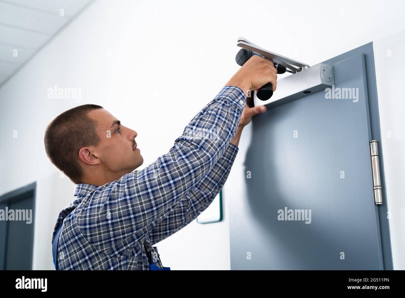 Handyman Installing And Fixing Automatic Door Closer. Maintenance And