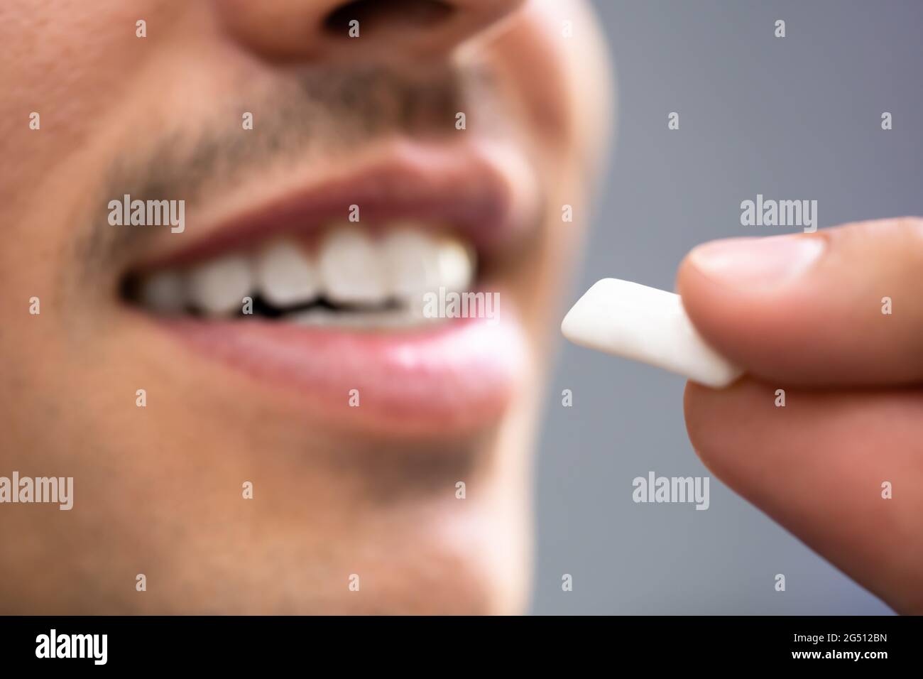 Man Using Nicotine Gum To Quit Smoking. Nicotine Replacement Therapy
