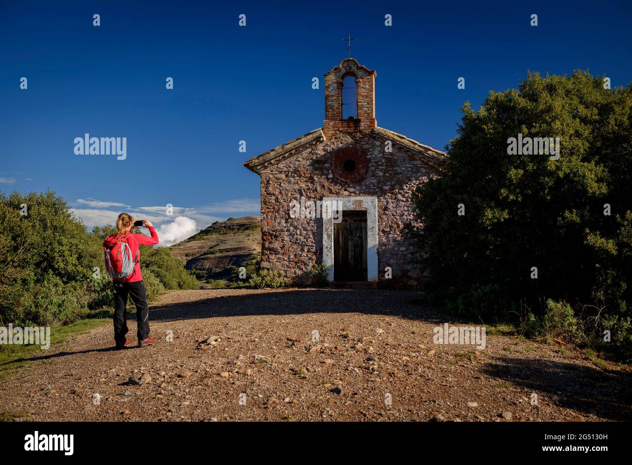 Hermitage of Sant Jaume de la Mata with a hiker photographing it (Bages, Barcelona, Catalonia, Spain) ESP: La ermita de Sant Jaume de la Mata (Bages) Stock Photo