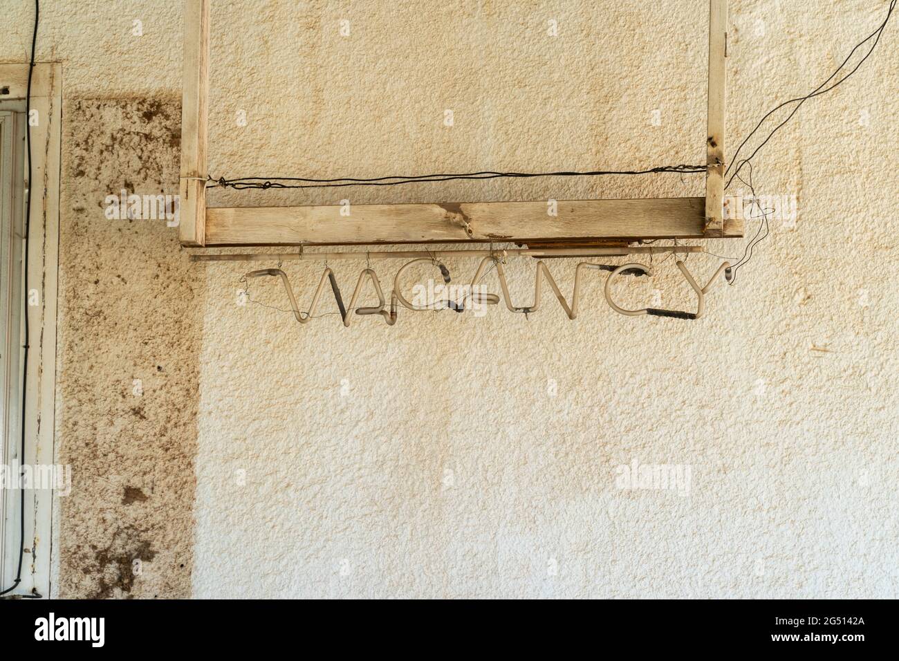 Old rusty vacancy sign against a wall at an abandoned motel Stock Photo