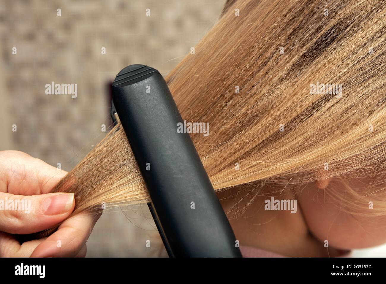 Hair straightening with an iron. Hairstyle at home. Baby hairstyle Stock  Photo - Alamy
