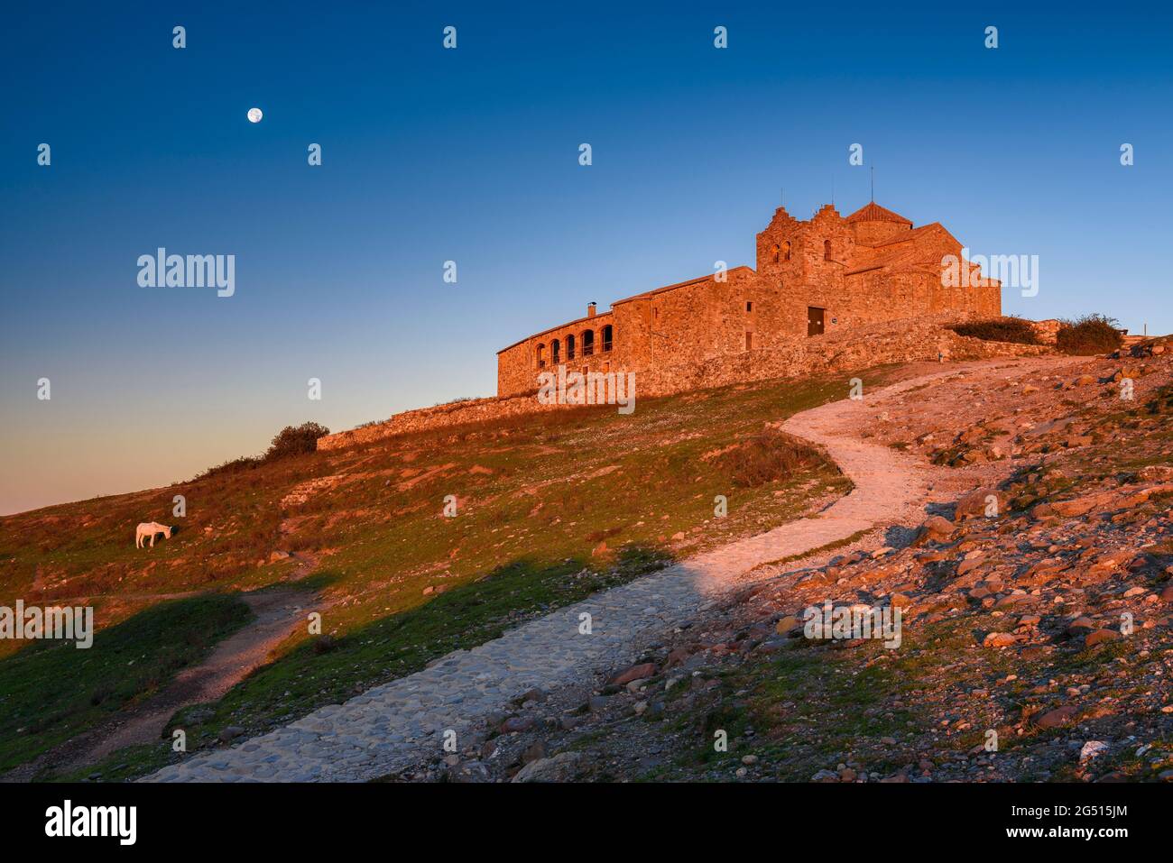 Sant Llorenç del Munt monastery at sunrise with the full moon (Vallès Occidental, Barcelona, Catalonia, Spain) Stock Photo