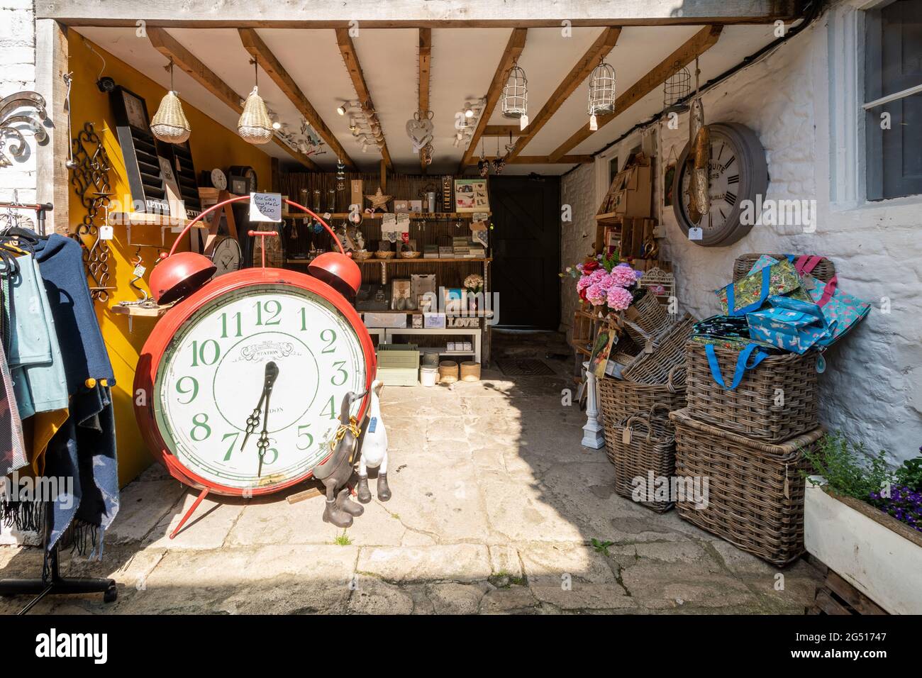 Gift shop in Lacock village, Wiltshire, England UK, with quirky big alarm clock on display and a variety of souvenirs and gifts Stock Photo