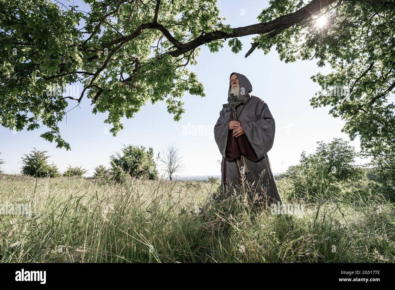 Portrait of a Monk in a black cassock in the forest, a wandering druid in an cassock. Stock Photo