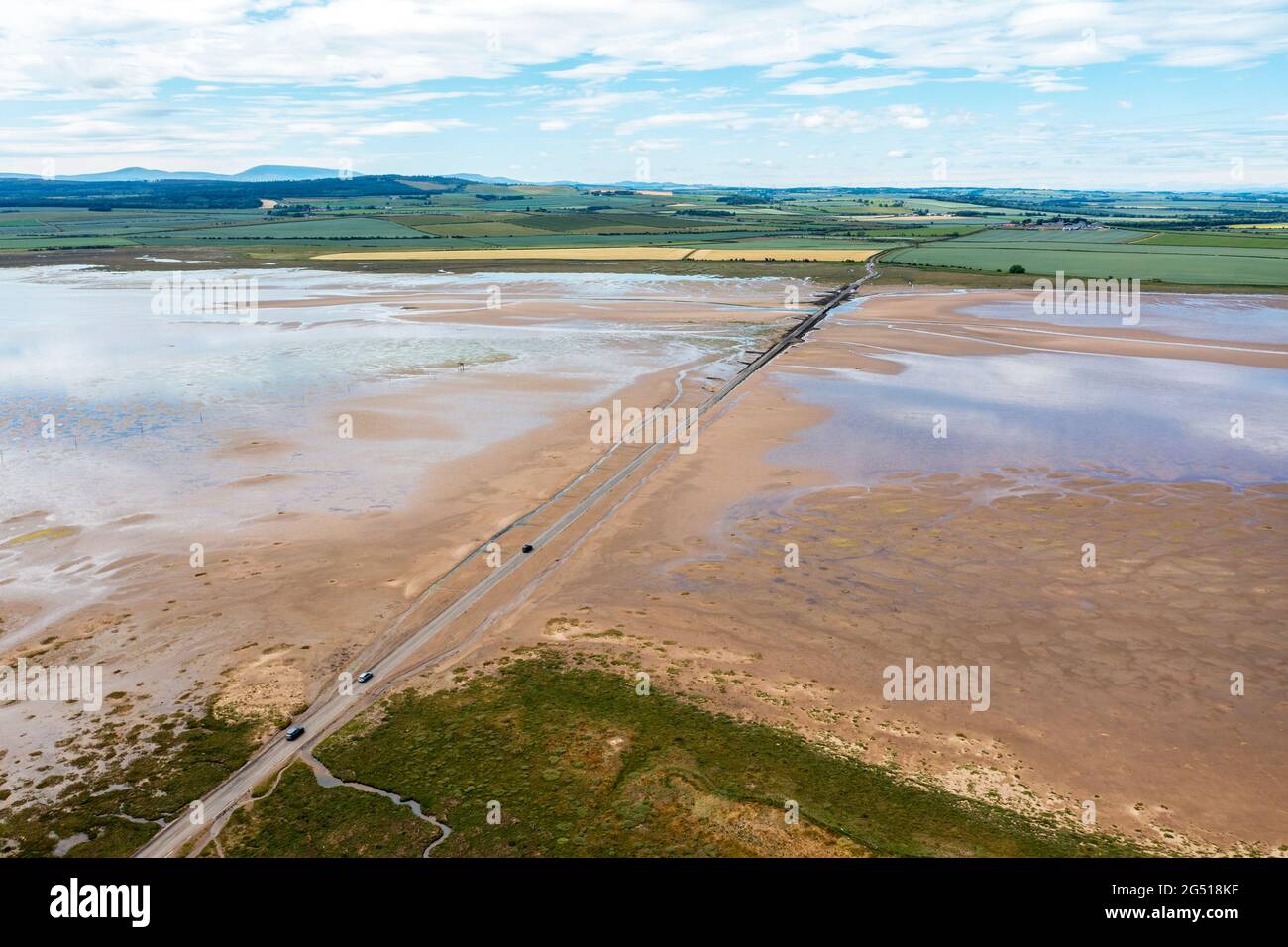 Aerial view of the Lindisfarne, (Holy Island) causeway that links it to the Northumberland mainland. The Causeway get covered by the sea at high tide Stock Photo