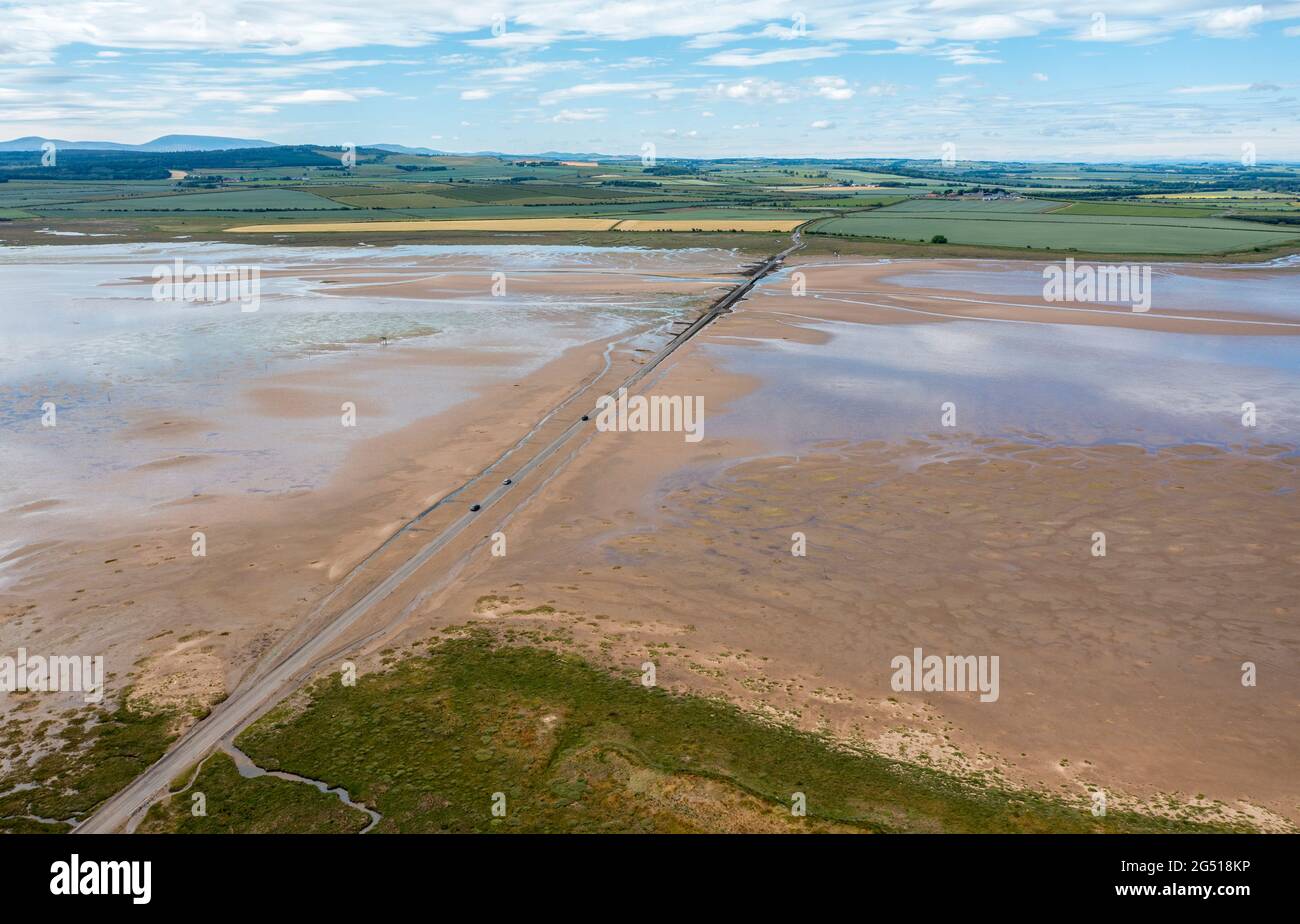 Aerial view of the Lindisfarne, (Holy Island) causeway that links it to the Northumberland mainland. The Causeway get covered by the sea at high tide Stock Photo