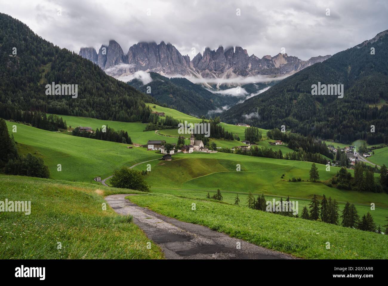 Hiking trail to St Magdalena church in Val di Funes valley, Dolomites, Italy. Furchetta and Sass Rigais mountain peaks in background Stock Photo