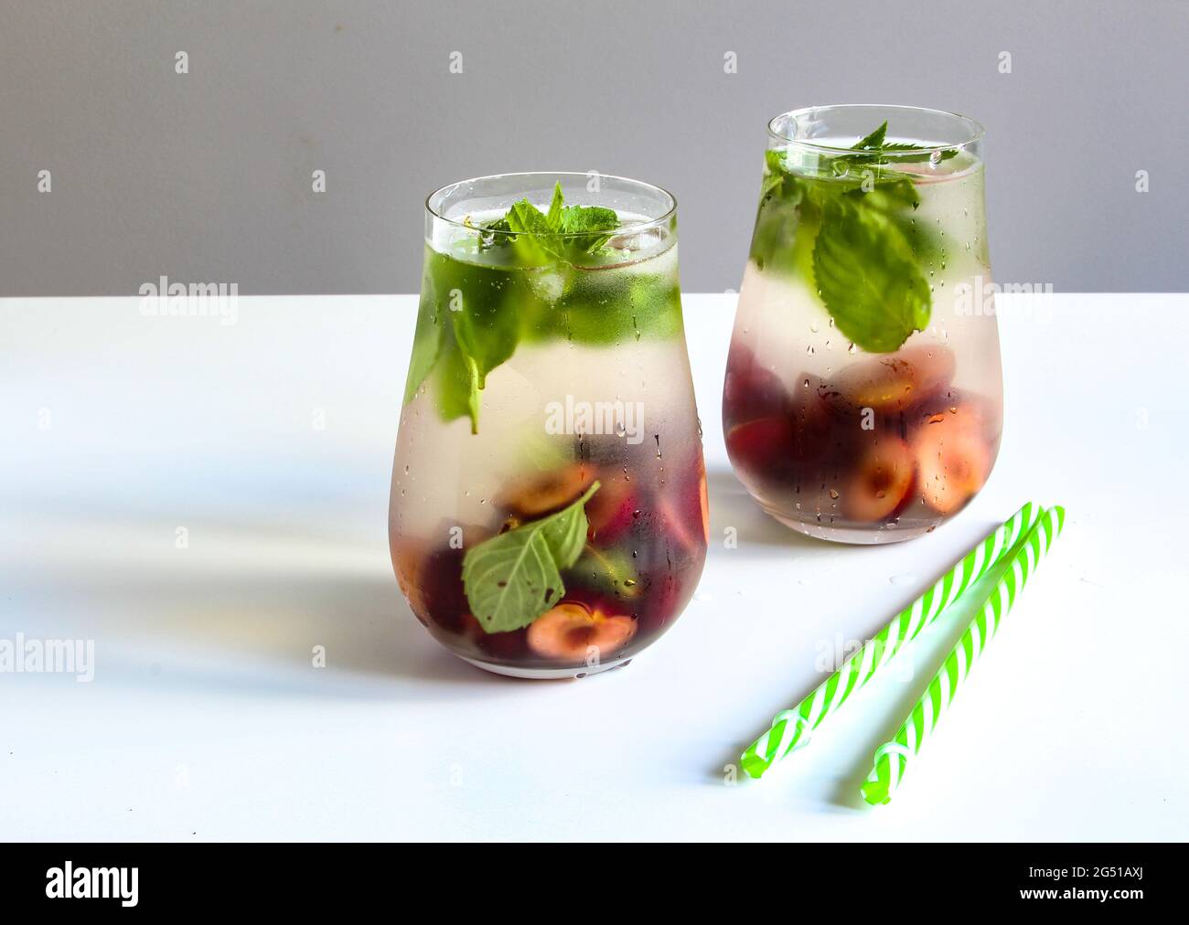 Cold drinks in small bottles. Cherries mint lemonade. Mojito coctail. Stock Photo