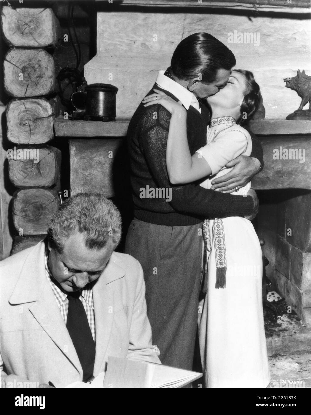 Director DELMER DAVES checks his script while CLARK GABLE and GENE TIERNEY rehearse a love scene on set candid during filming of NEVER LET ME GO 1953 director DELMER DAVES from novel Come The Dawn by Paul Winterton producer Clarence Brown Metro Goldwyn Mayer Stock Photo