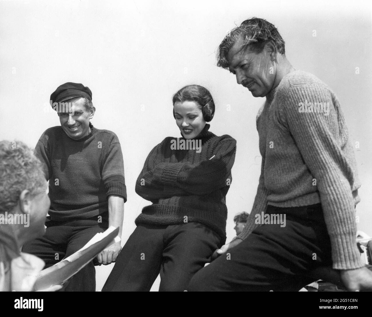Director DELMER DAVES BERNARD MILES GENE TIERNEY and CLARK GABLE on set location candid in Cornwall England during filming of NEVER LET ME GO 1953 director DELMER DAVES from novel Come The Dawn by Paul Winterton producer Clarence Brown Metro Goldwyn Mayer Stock Photo