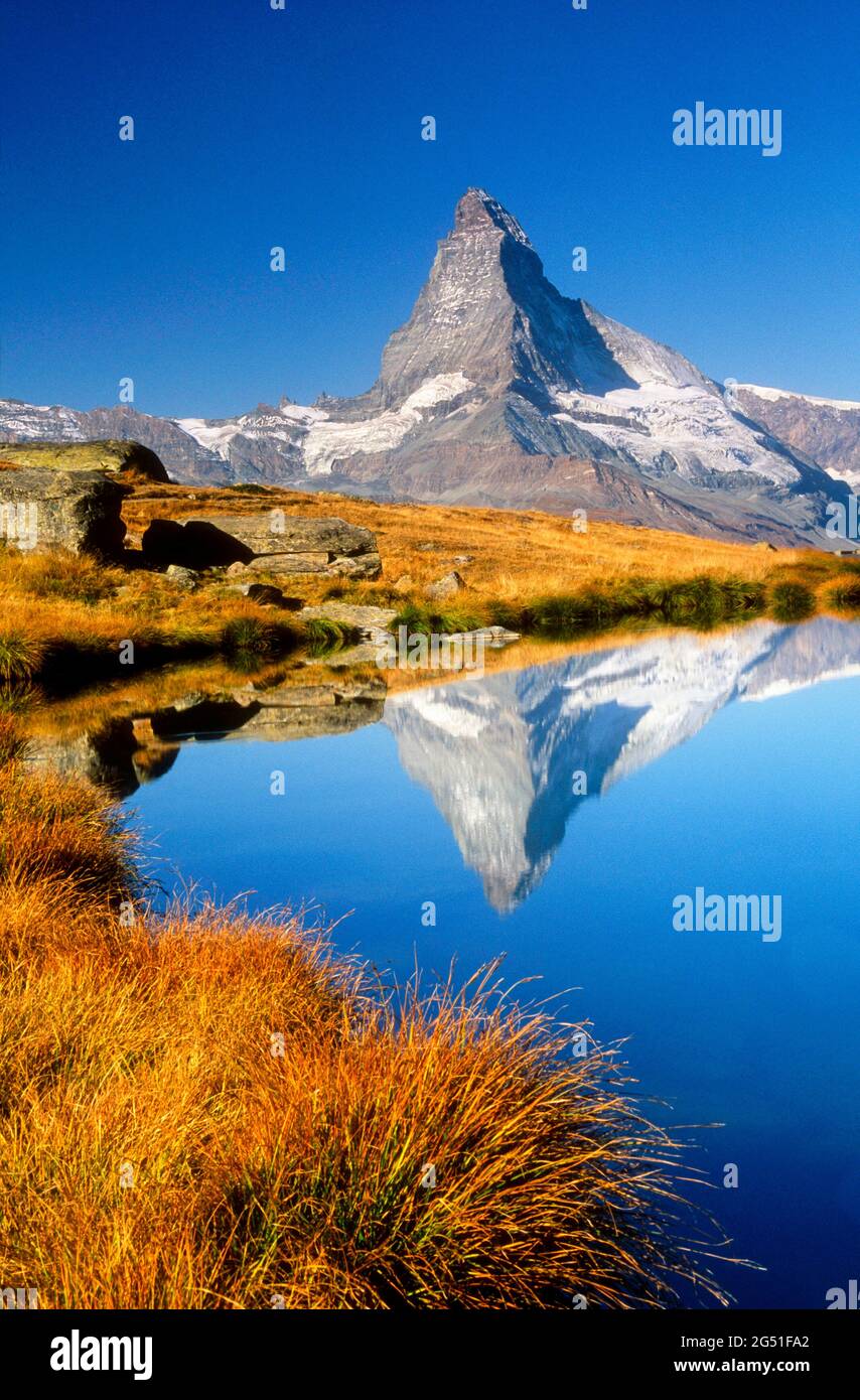 Landscape with view of Matterhorn reflecting in lake under clear sky, Zermatt, Valais Canton, Switzerland Stock Photo