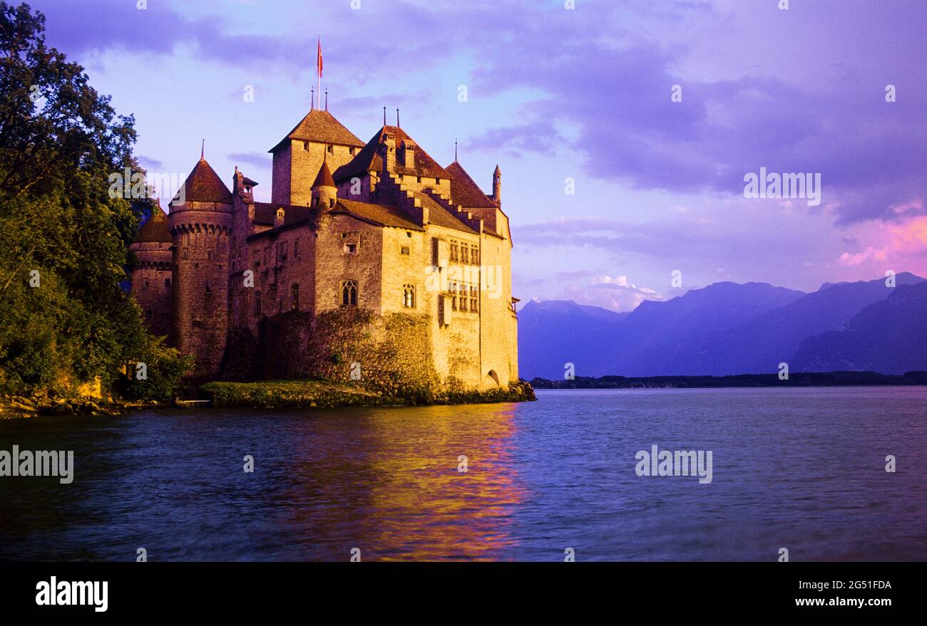 Chillon Castle on shore of Lake Geneva at sunset, Vaud Canton, Switzerland Stock Photo