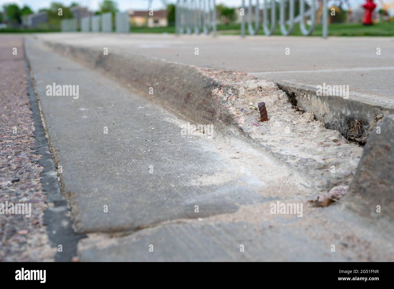 Broken Sidewalk Curb With Exposed Rebar And Jagged Edges That Could 