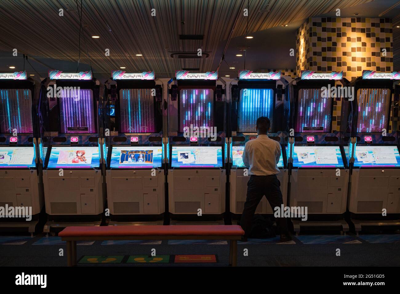 A man playing a Chunithm arcade machine in Japan Stock Photo