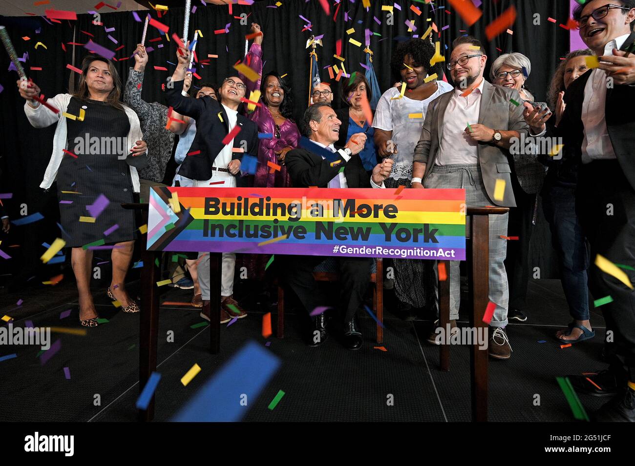 New York, USA. 24th June, 2021. People celebrate after New York Gov. Andrew Cuomo (seated) signs the Gender Recognition Act on the 10th anniversary of the Marriage Equality Act, in honor of Pride Week, at Pier 59 in New York, NY, June 24, 2021. The Gender Recognition Act extends protections for transgender and non-binary New Yorker, allowing people to change their gender on their birth certificates to conform to how they identify themselves. (Photo by Anthony Behar/Sipa USA) Credit: Sipa USA/Alamy Live News Stock Photo