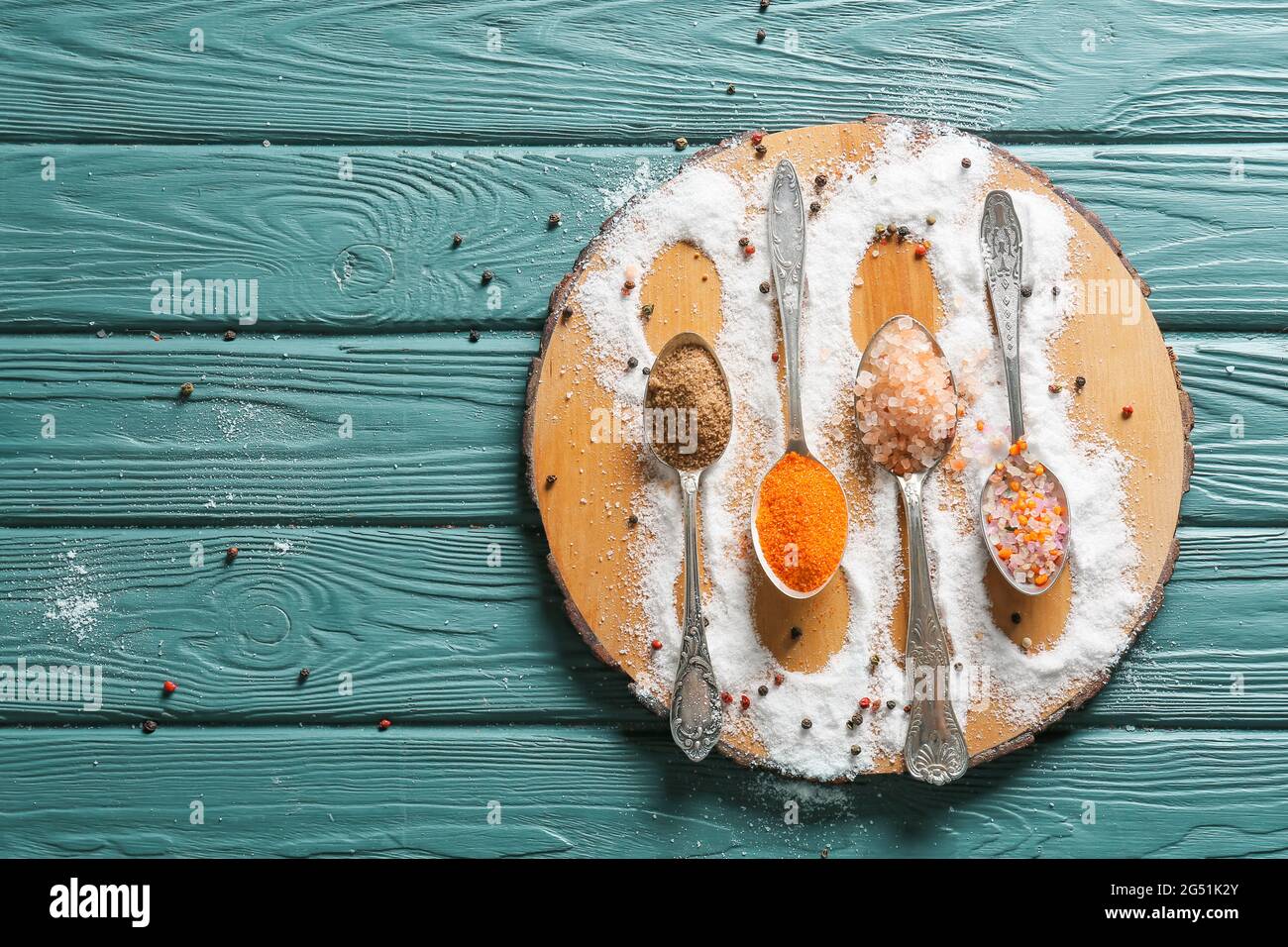 Composition with different salt and peppercorns on color wooden background Stock Photo
