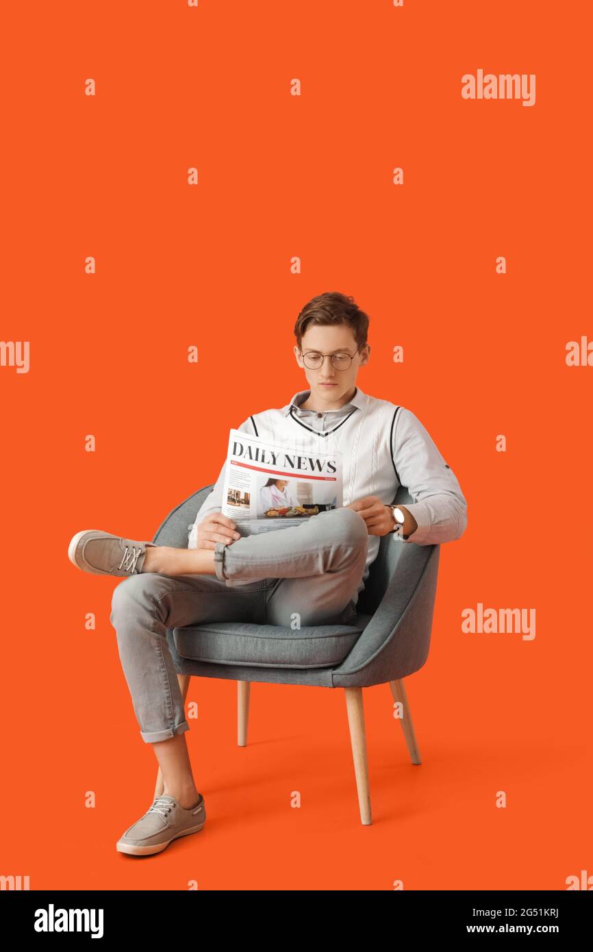 Young Man Reading Newspaper While Sitting In Armchair On Color Background Stock Photo Alamy Young Man Reading Newspaper While Sitting In Armchair On Color Background Stock Photo Alamy