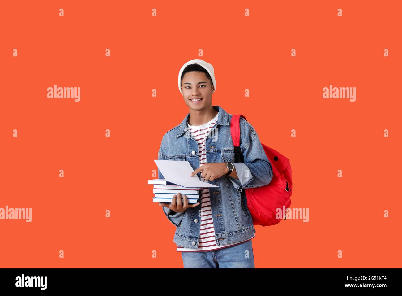 Male African-American student with books on color background Stock ...
