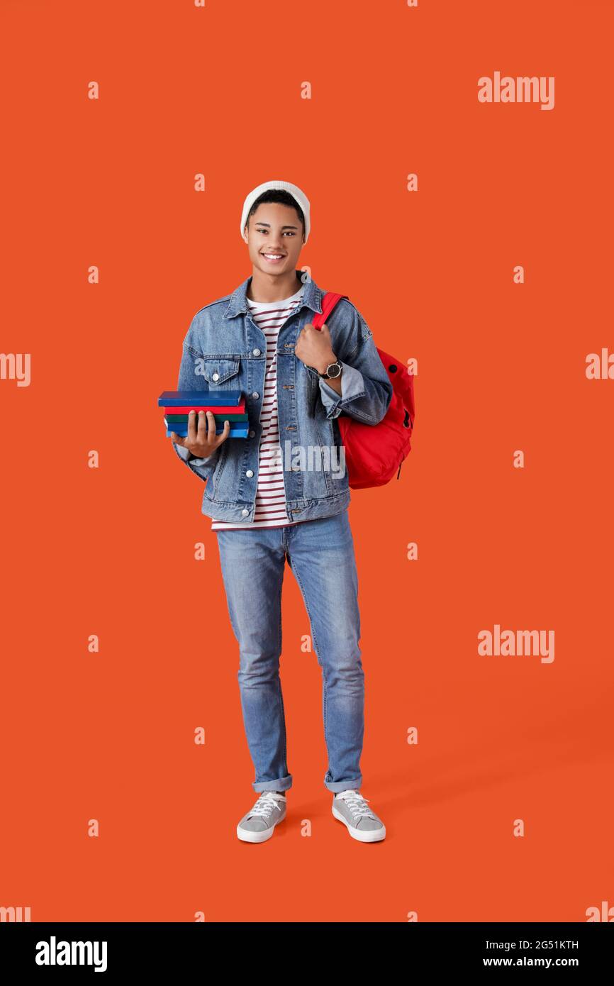 Male African-American student with books on color background Stock ...