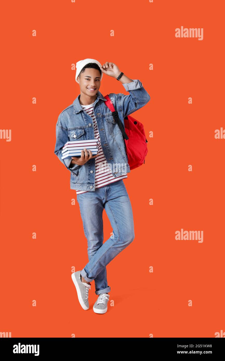 Male African-American student with books on color background Stock ...
