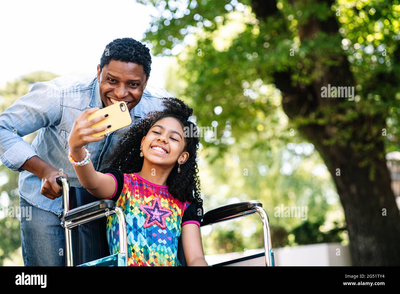Girl in a wheelchair and her father taking a selfie with phone Stock ...
