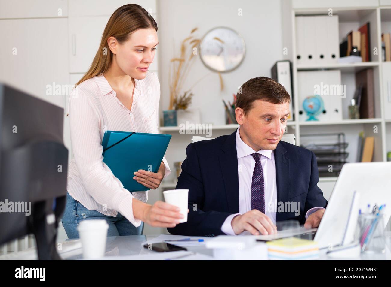 Female assistant bringing coffee to boss Stock Photo Alamy