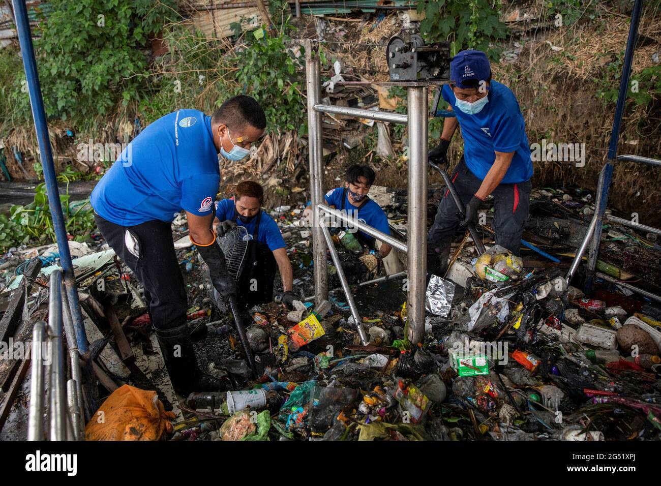 Members of the River Warriors gather trash to a 'trash boat' from the heavily polluted San Juan River, a tributary of Pasig River, in Mandaluyong City, Philippines, June 21, 2021. The 'River Warriors' is a group of volunteers founded over a decade ago whose sole purpose was to pick up garbage in and around Manila's Pasig River. Picture taken June 21, 2021. REUTERS/Eloisa Lopez Stock Photo