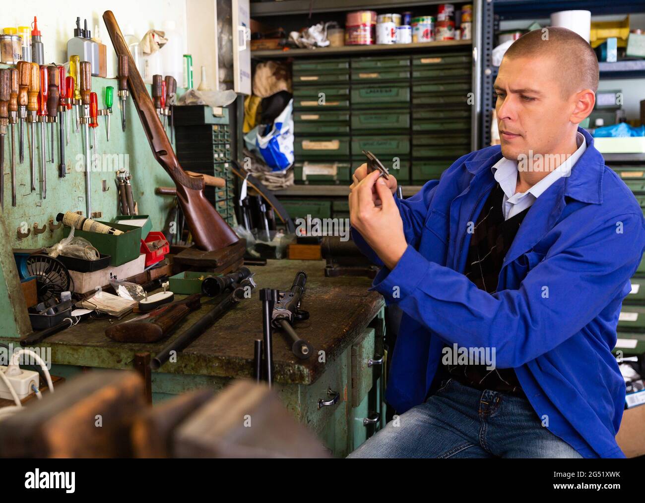 Craftsman of weapons using vernier caliper to measure shotgun