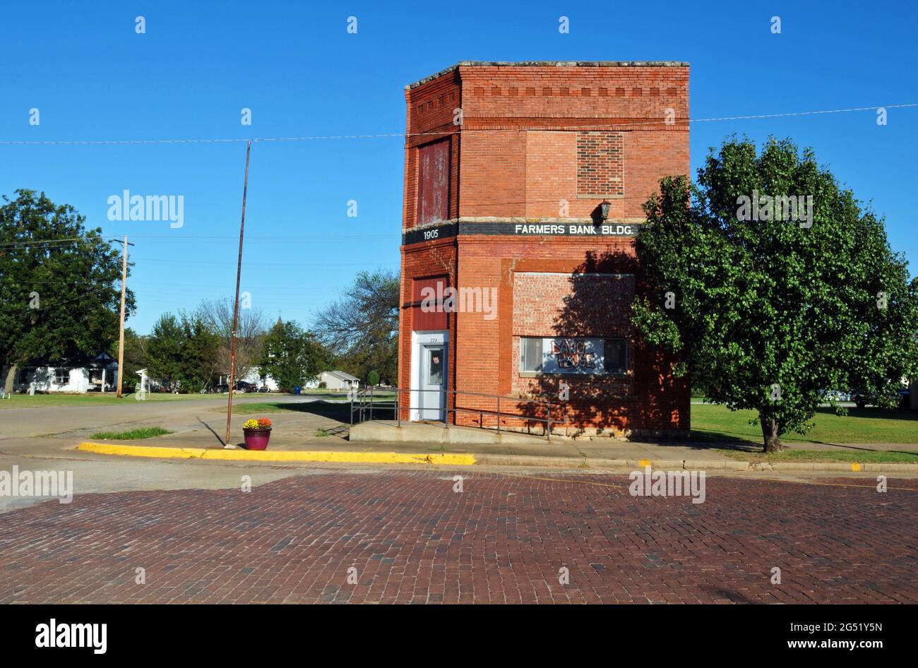 The 1905 Farmers Bank building stands along the red brick-paved Broadway street in the historic Route 66 town of Davenport, Oklahoma. Stock Photo
