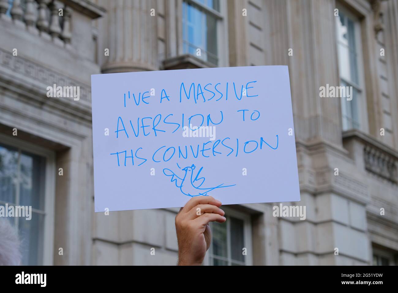 A protester holds up a banner at a demonstration outside the Cabinet Office calling for the banning of gay conversion therapy. Stock Photo