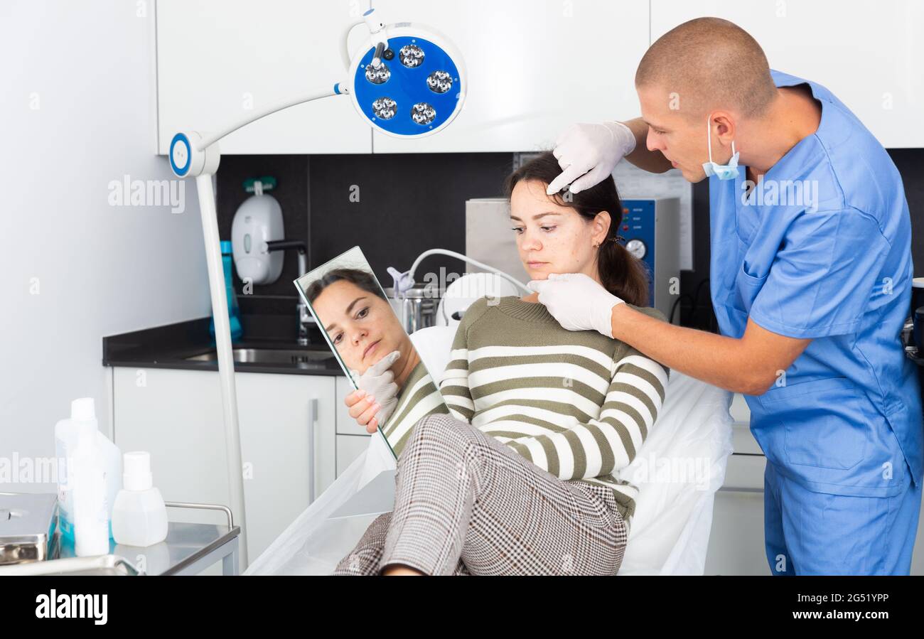 Cosmetician explaining hardware facial procedure to female client Stock ...