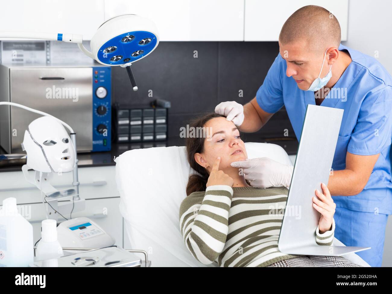 Cosmetician explaining hardware facial procedure to female client Stock ...