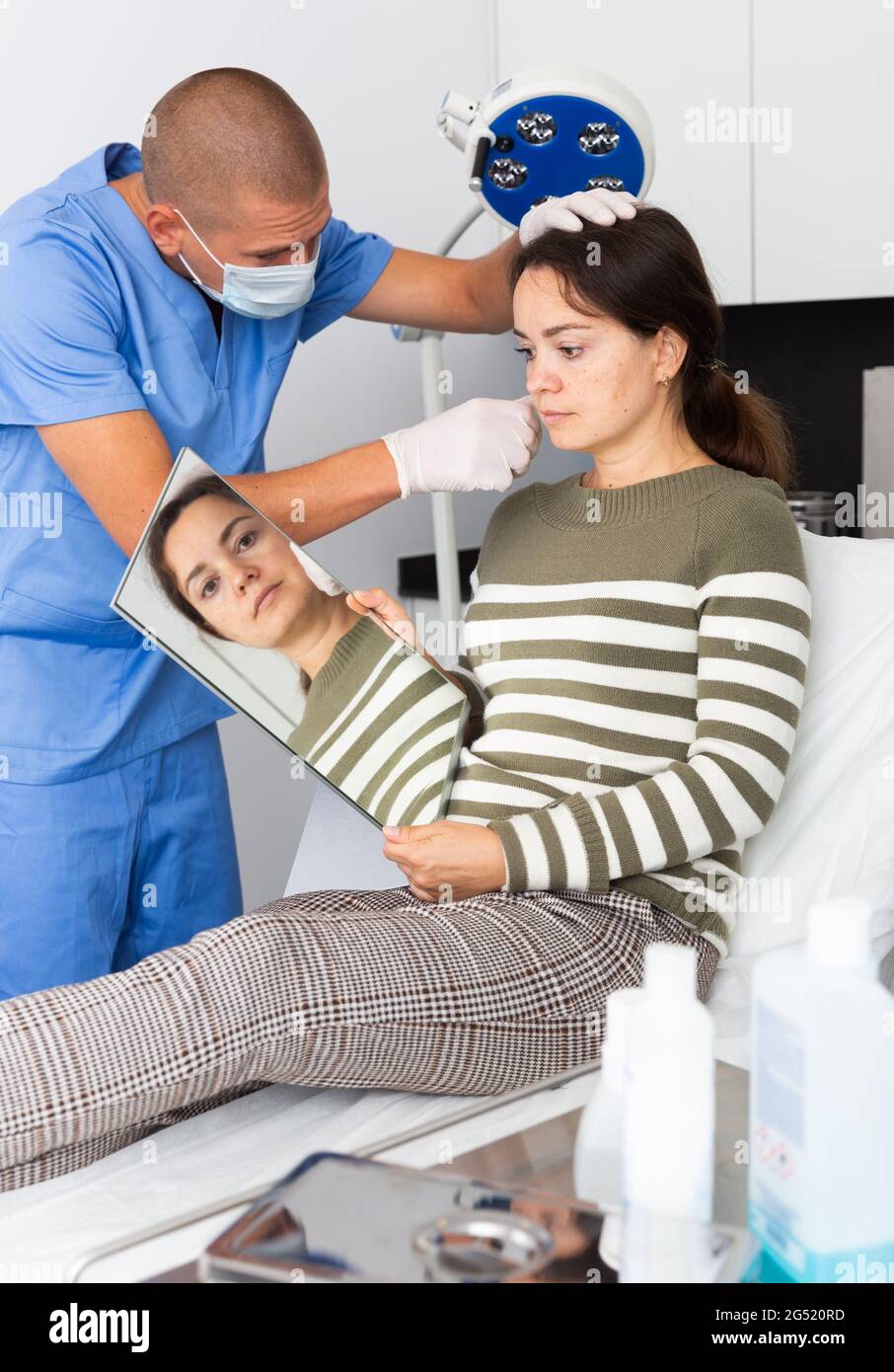 Cosmetician explaining hardware facial procedure to female client Stock ...