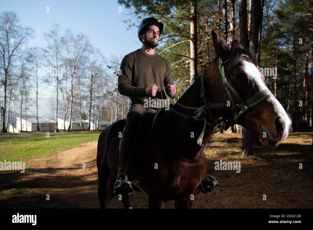 Portrait of Confident Male Jockey With Horse Standing on Field Stock Photo